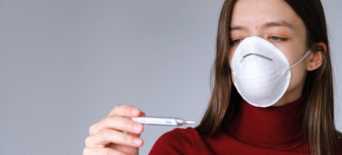 woman-in-face-mask-checking-thermometer-3987152 Detector de Covid-19 ce măsoară temperatura și indică prezența măștii de protecție, folosit în Taiwan